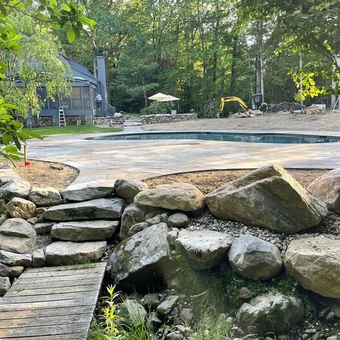 New gunite pool under construction on a wooded lot