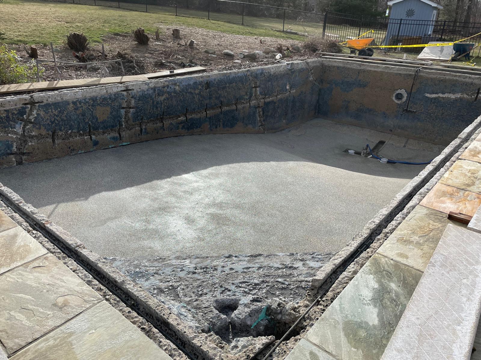 Pool shell stripped back to bare structure with taped seams during demolition